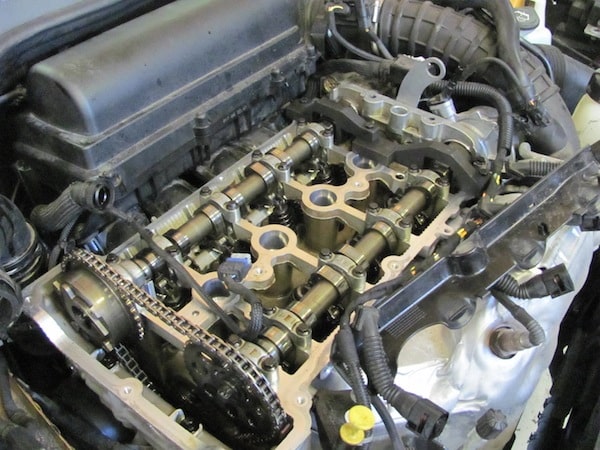 Exposed car engine with visible camshafts and timing chain