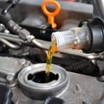 Pouring motor oil into car engine