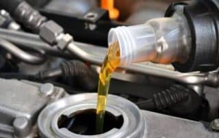 Pouring motor oil into car engine