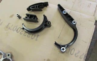 Black automotive chain guides on cardboard surface