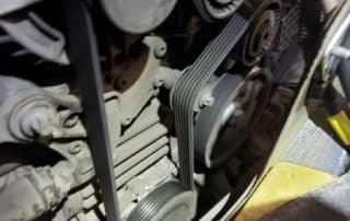 Close-up of car engine serpentine belt and pulleys