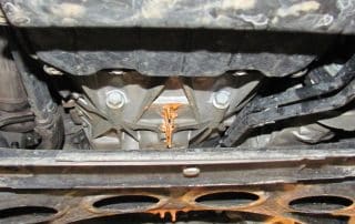 Melted orange substance dripping under car chassis