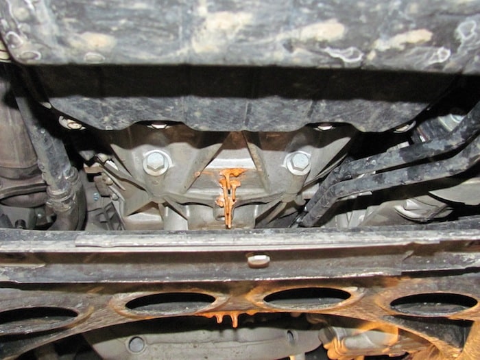 Melted orange substance dripping under car chassis