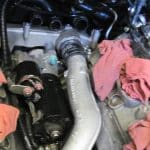 Car engine bay with starter motor and hoses
