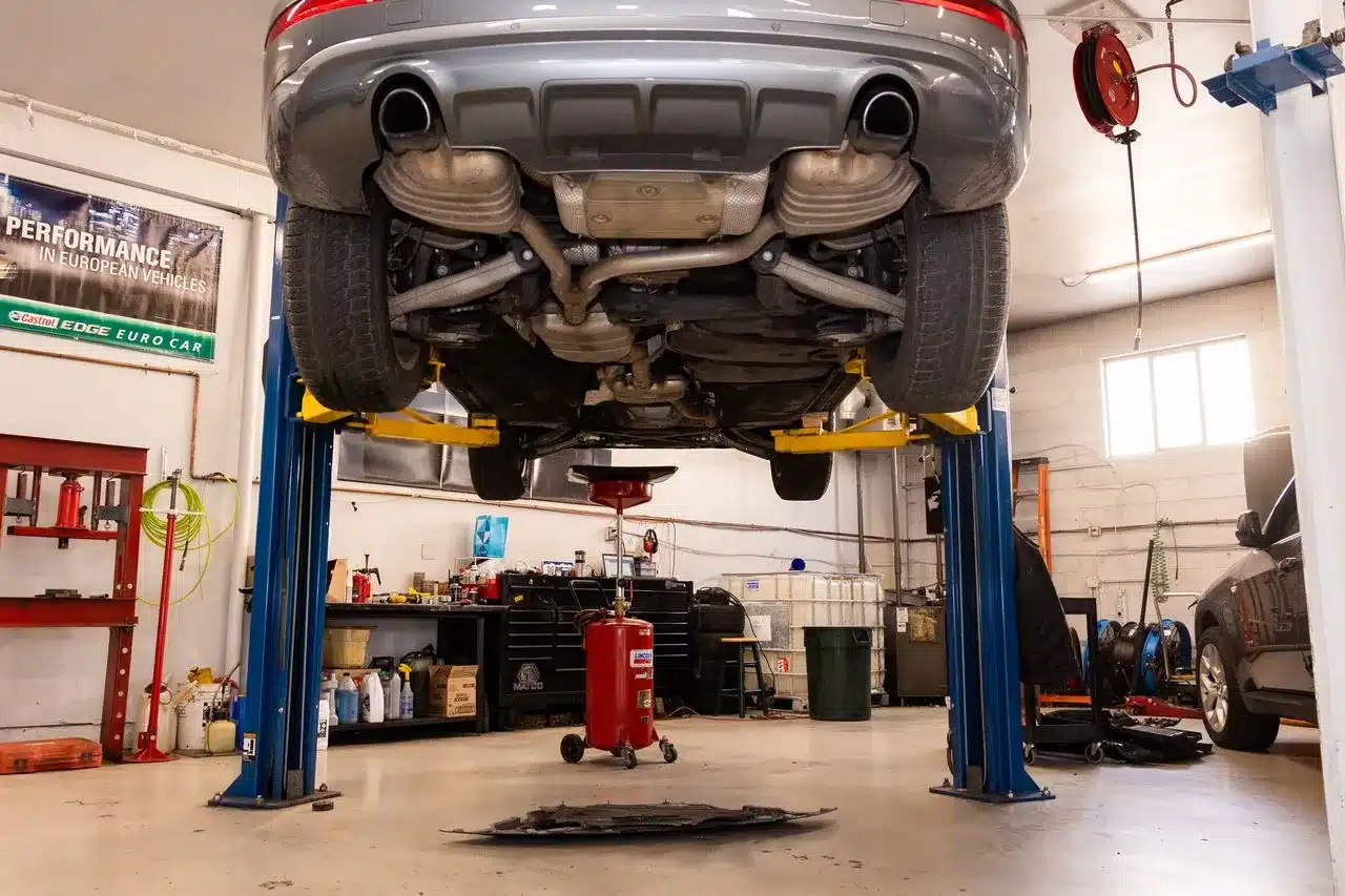 Car elevated on lift in auto repair shop
