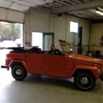 Vintage orange convertible inside auto repair shop