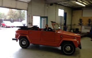Vintage orange convertible inside auto repair shop