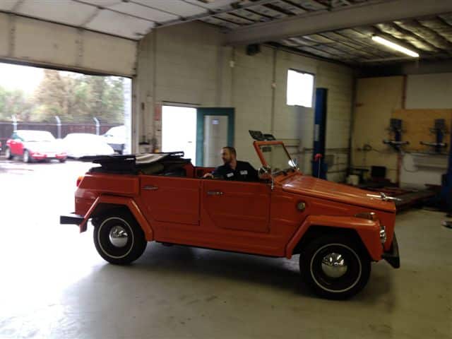 Vintage orange convertible inside auto repair shop