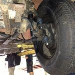 Underside of vehicle suspension and rear wheel on lift