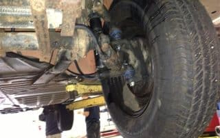 Underside of vehicle suspension and rear wheel on lift