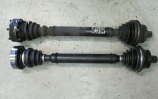 Two automotive CV axle shafts on floor