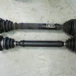 Two automotive CV axles on workshop floor